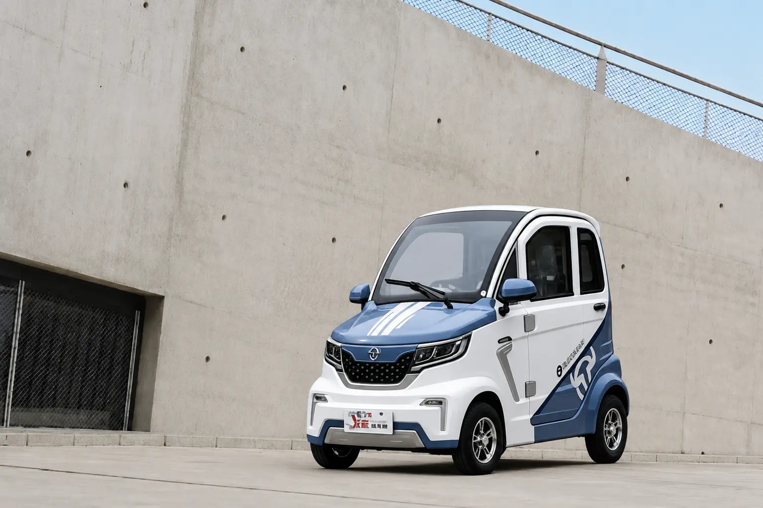 Blue and white Dongwei compact electric vehicle outside a modern concrete building